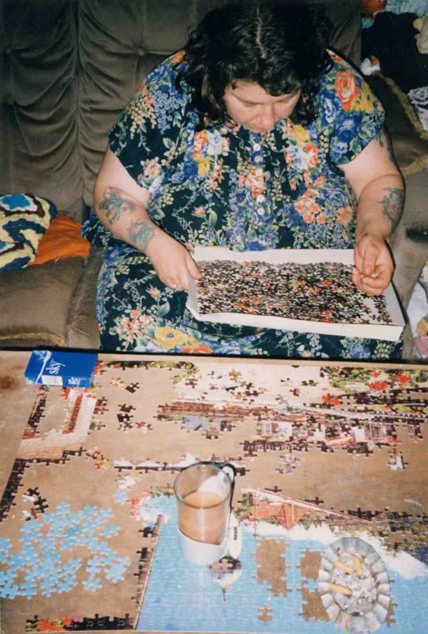 Donna che compone un puzzle sul divano di casa