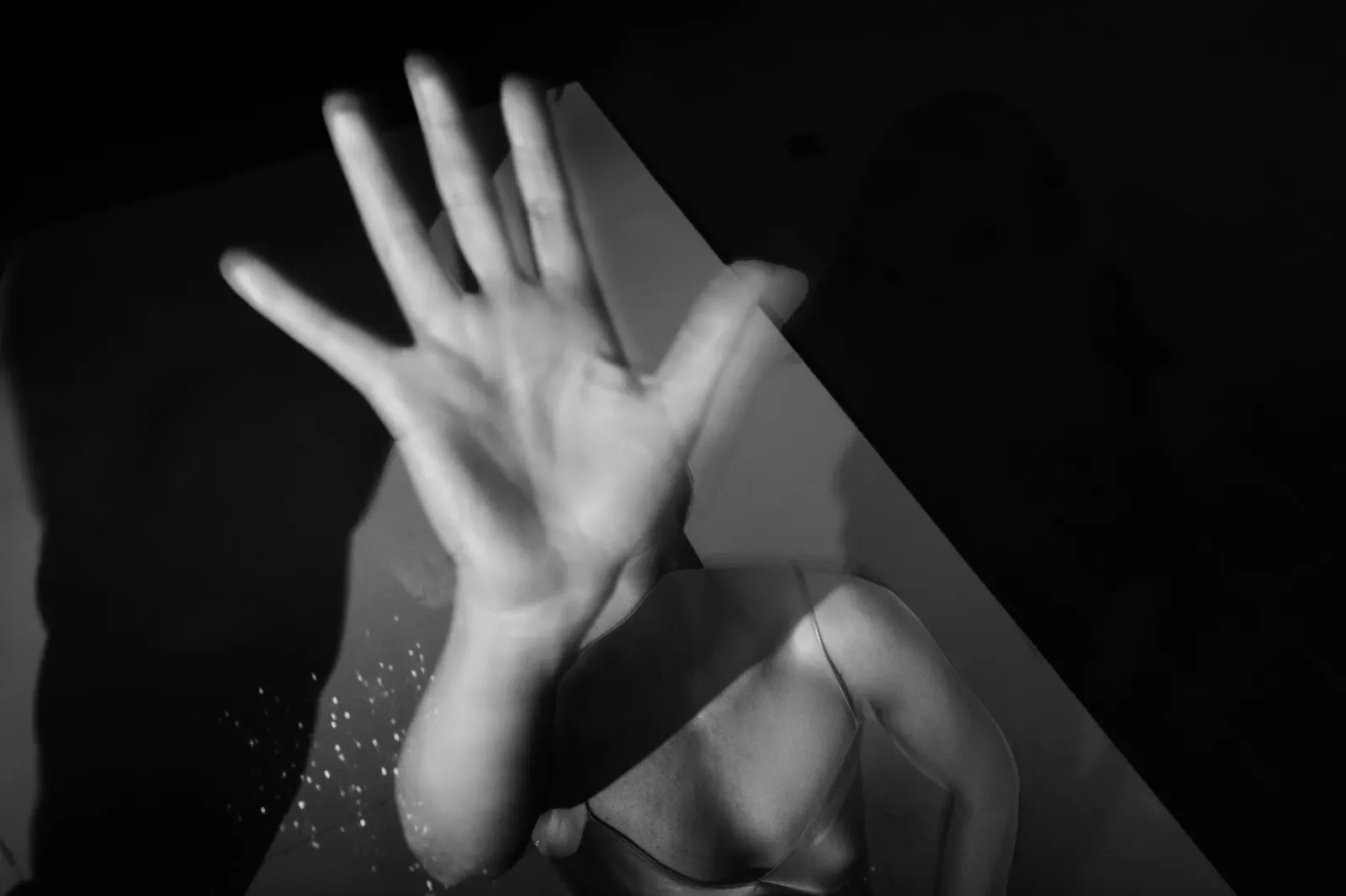 An open hand held up to the camera, in black and white