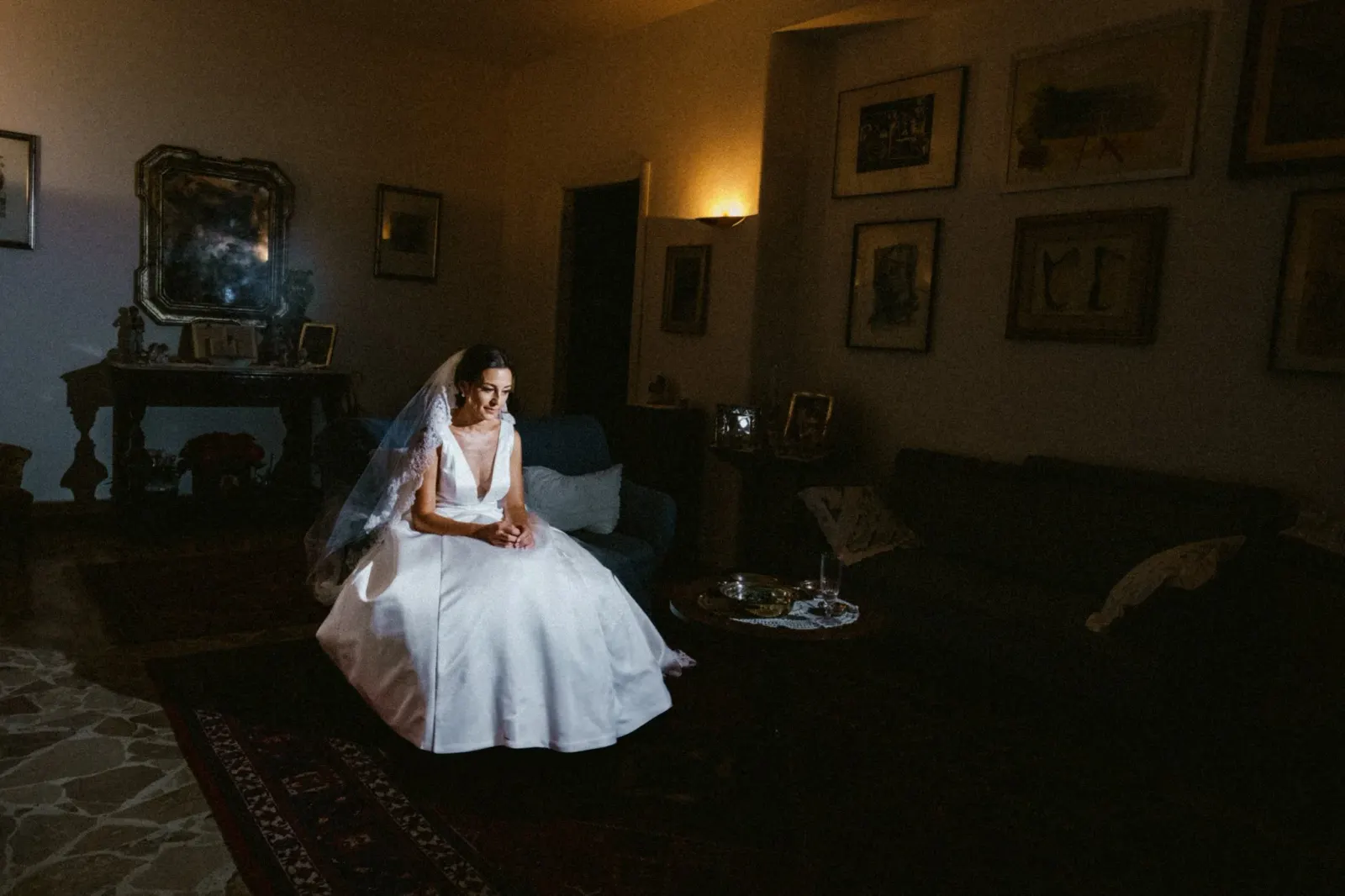 The bride sitting on the floor of a dim living room