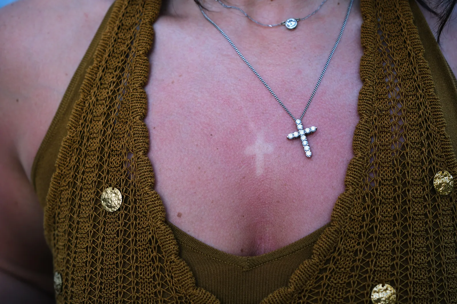 A cross pendant against a sunburnt neckline