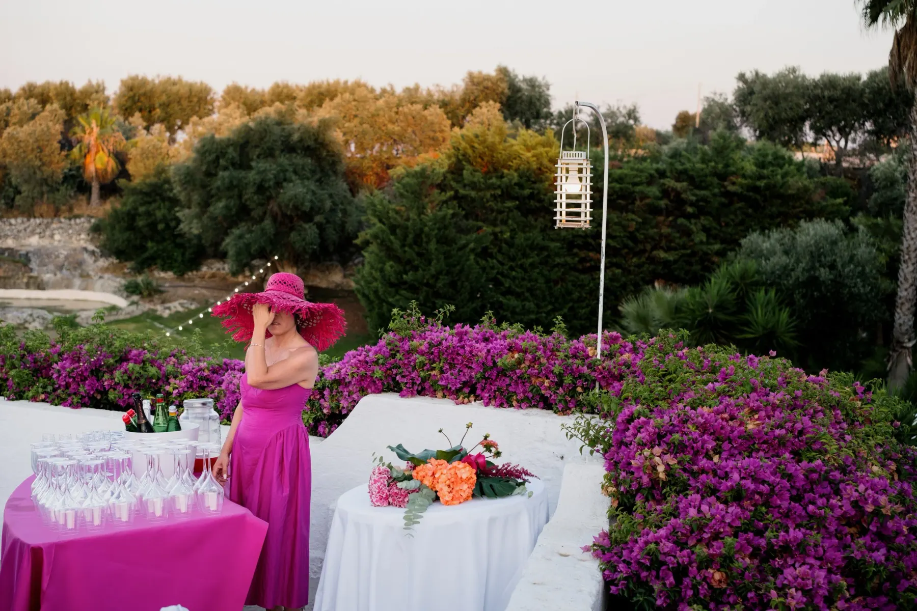 A drinks table set under the bougainvillea in a masseria garden